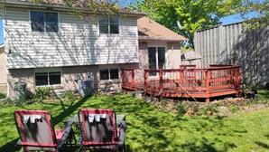 A house with a deck, two lawn chairs, and a small garden area. - Perfect 3 bedroom house in prime location of South Windsor. max 5 guests (Windsor)