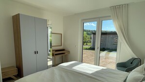 A bedroom with a bed, a desk, a chair, and a sliding glass door leading to an outdoor area. - Vacation home Wiesenblick (Spangenberg)