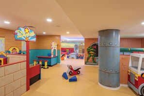 A children's play area with a diner sign, play tables, a fire truck, and a large cylindrical structure. - U Magic Palace (Eilat)
