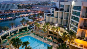 A hotel with a pool, multiple floors, and a view of the cityscape. - U Magic Palace (Eilat)