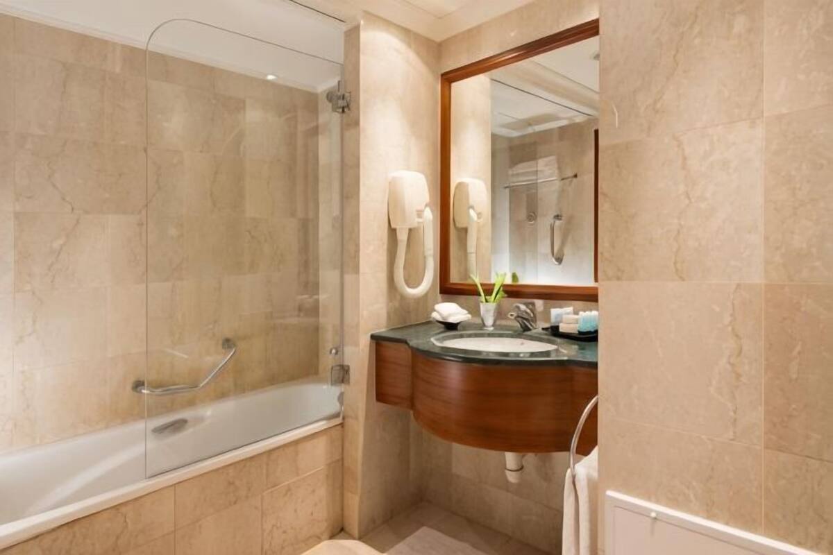 Une salle de bain avec une baignoire, un lavabo, un miroir et une douche.
