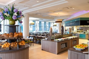 Zona de buffet con diversas opciones de comida y un centro de mesa floral.