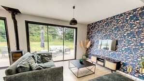 Un salon moderne avec une cheminée, un canapé, une table basse et un téléviseur.