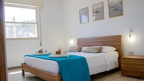 Een netjes opgemaakt slaapkamer met een houten bed, een blauw dekbed en een nachtkastje van hout.