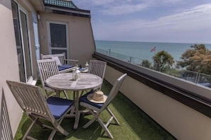 A balcony with a table and chairs, a view of the sea, and a flag. - Beachcroft Hotel, BW Signature Collection by Best Western (Felpham)