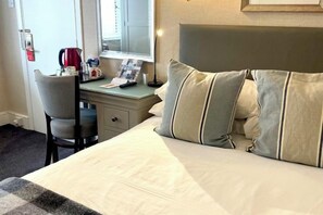 A hotel room with a bed, a desk with a chair, a small table, and a window. - Beachcroft Hotel, BW Signature Collection by Best Western (Felpham)