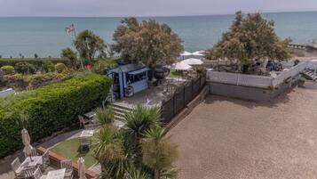 A beachside property with a patio, seating area, and a view of the sea.
