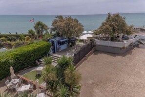 A beachside property with a patio, seating area, and a view of the sea. - Beachcroft Hotel, BW Signature Collection by Best Western (Felpham)