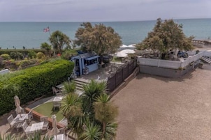 A beachside property with a patio, seating area, and a view of the sea.