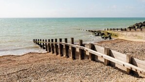 A pebble beach with a wooden jetty extending into the water. - Beachcroft Hotel, BW Signature Collection by Best Western (Felpham)