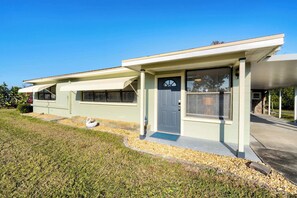 A two-story house with a covered porch, a front door, and a garage. - Break of Dawne (Kissimmee)