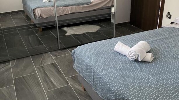 A hotel room with a bed, a mirror, and a door. - Apartments Stone House Murter (Murter-Kornati)