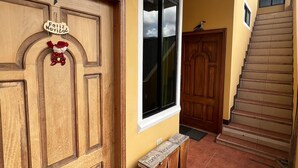 Ein Flur mit Holztür, Fenster und Treppe.