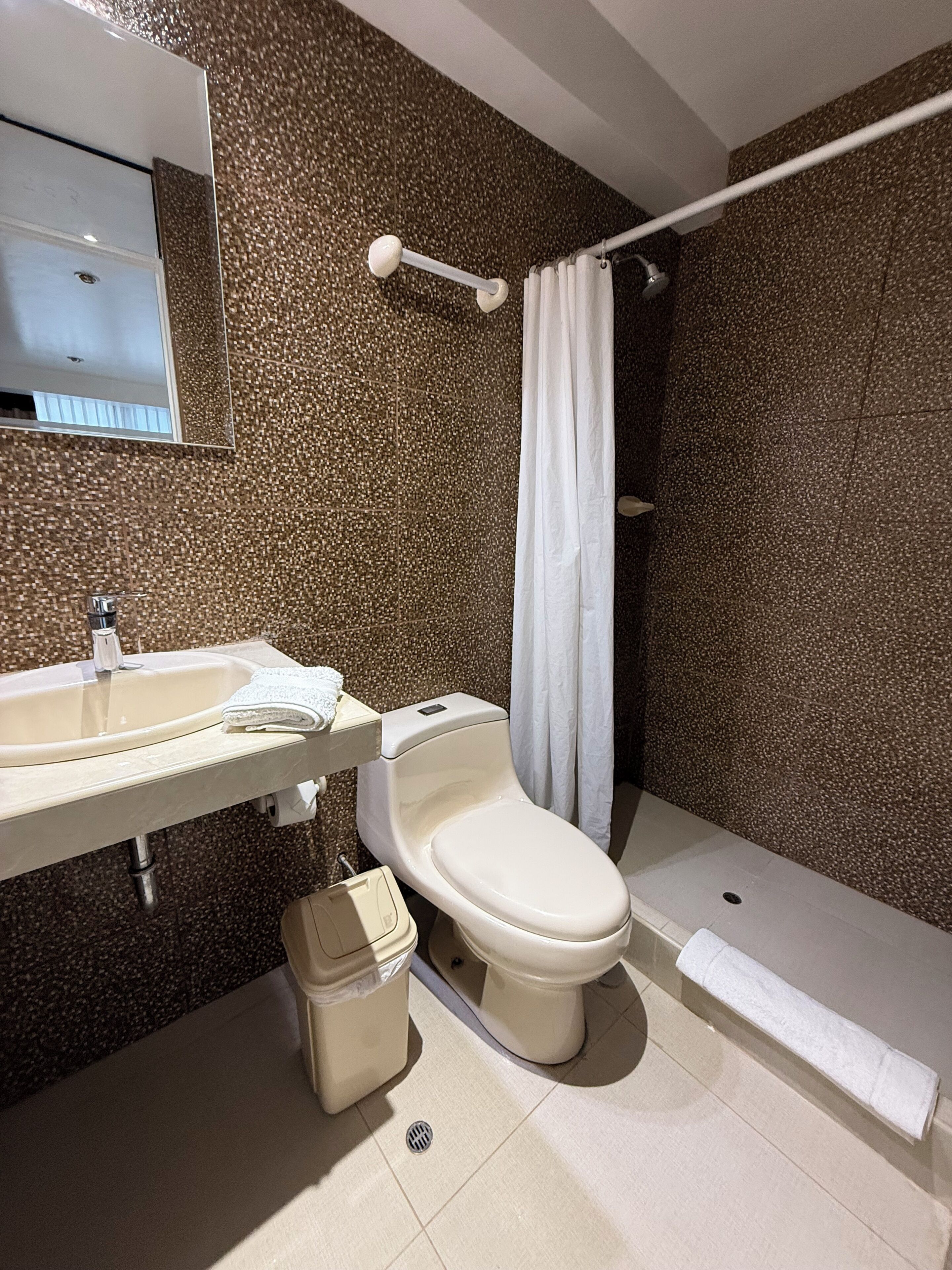 Un baño moderno con lavamanos, inodoro y ducha.