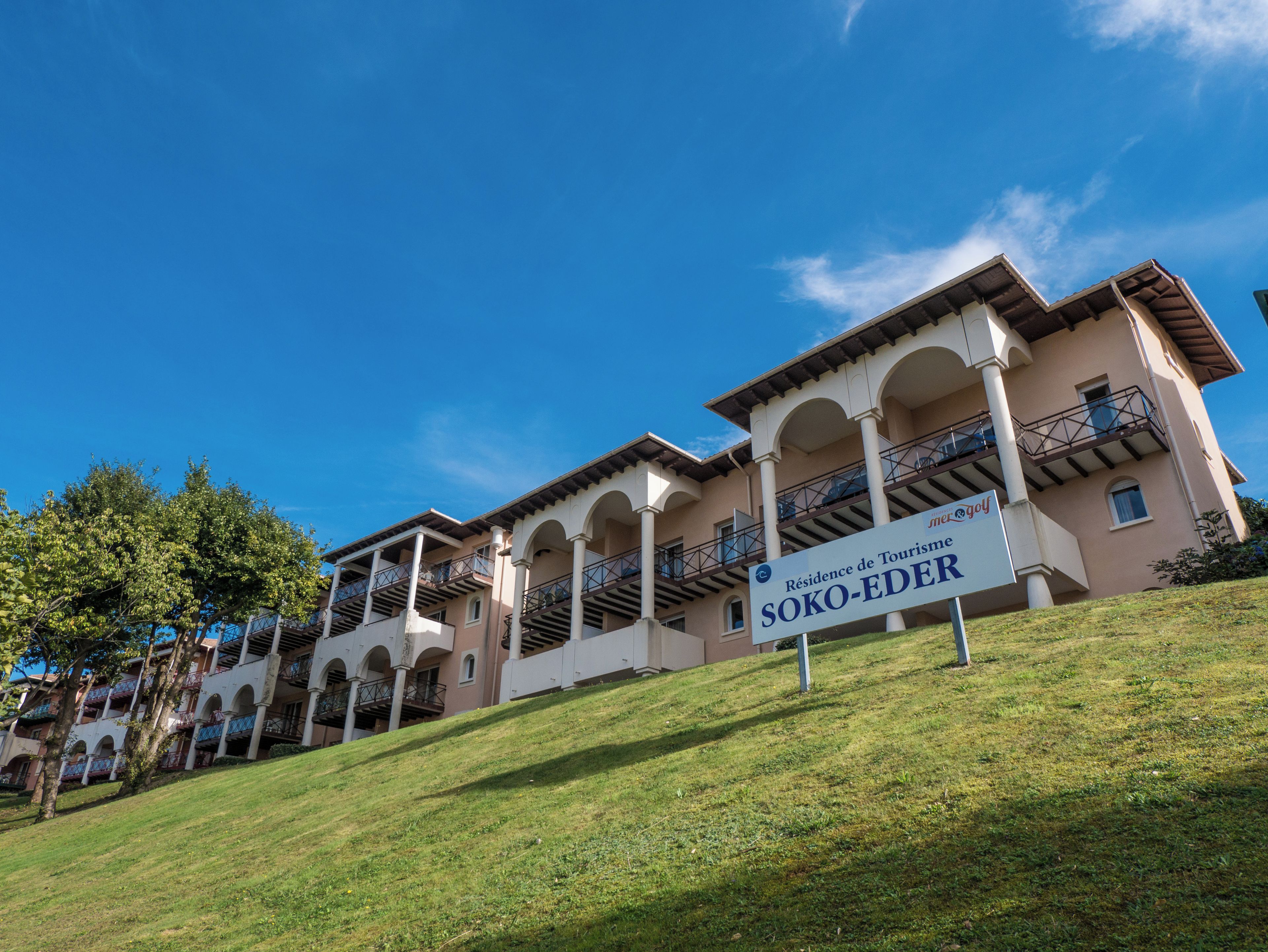 Een meerlaags hotel met een bord waarop staat 'Residence de Tourism Soko-Eder'.