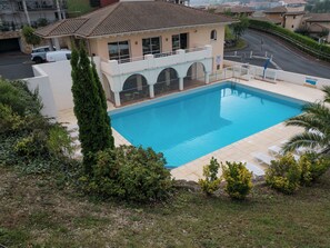 A swimming pool with a house in the background. - Résidence Mer & Golf Soko-eder (Ciboure)
