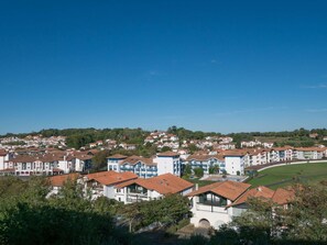 A residential area with multi-story buildings, a clear sky, and green hills in the background. - Résidence Mer & Golf Soko-eder (Ciboure)