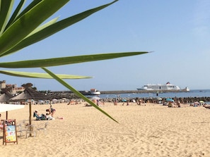 A beach with people, umbrellas, and a cruise ship in the background. - Résidence Mer & Golf Soko-eder (Ciboure)