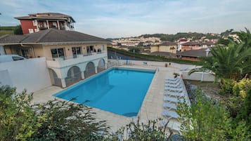 Una piscina con vista a una zona residencial al fondo.