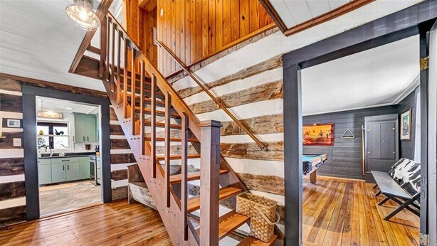 A wooden staircase leading to a loft area with a pool table and seating. - Charming, fully renovated 19th century cabin with spectacular views. 4 BR, 2 BA. (Arrington)