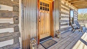A log cabin with a wooden front door, a porch with two chairs, and a metal railing. - Charming, fully renovated 19th century cabin with spectacular views. 4 BR, 2 BA. (Arrington)