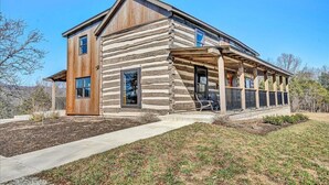 A log cabin with a covered porch and large windows. - Charming, fully renovated 19th century cabin with spectacular views. 4 BR, 2 BA. (Arrington)