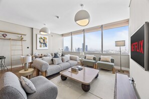 Leilighet – business, byutsikt | Oppholdsområde | En 55-tommers smart-TV med kabel-kanaler samt Netflix og filmkjøp