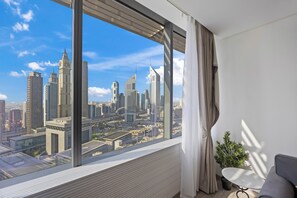 Une chambre d’hôtel moderne dotée d’une grande fenêtre donnant sur le paysage urbain.