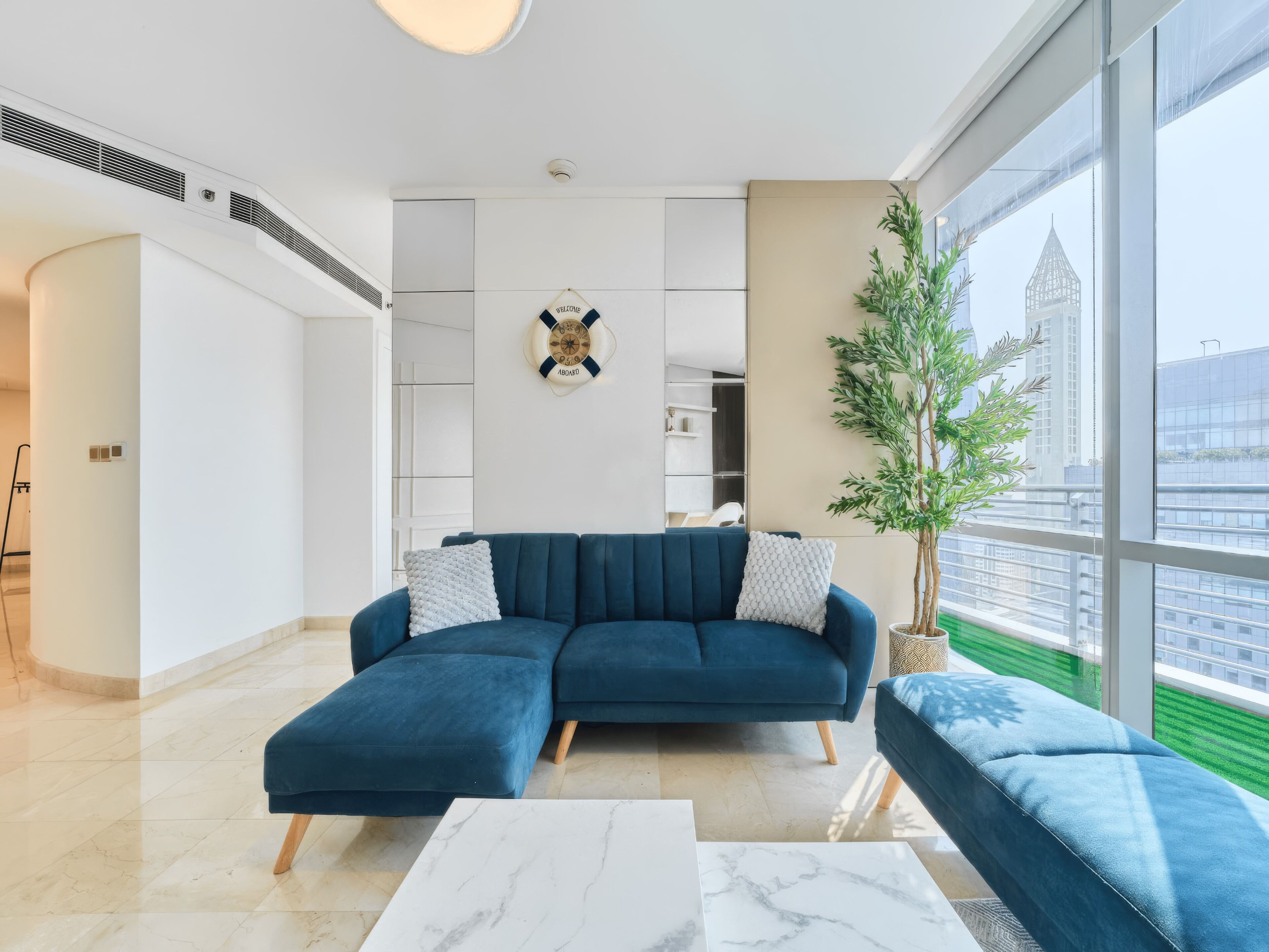 A modern living room with a sectional sofa, a coffee table, and a potted plant.