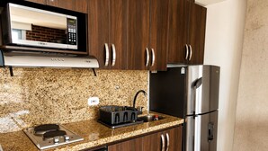 A kitchen with a microwave, stove, sink, and stainless steel refrigerator. - Laureles Deluxe Apartment  Medellin  (Medellín)