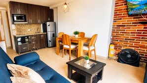A compact living space with a sofa, dining table, and kitchenette. - Laureles Deluxe Apartment  Medellin  (Medellín)