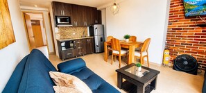A compact living space with a sofa, dining table, and kitchenette. - Laureles Deluxe Apartment  Medellin  (Medellín)