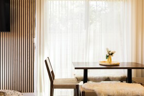 A dining area with a wooden table, chairs, and a vase with flowers.