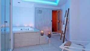 Une salle de bain moderne dotée d’une douche à parois de verre, d’une baignoire sur pieds et d’une porte en bois donnant sur une autre pièce.