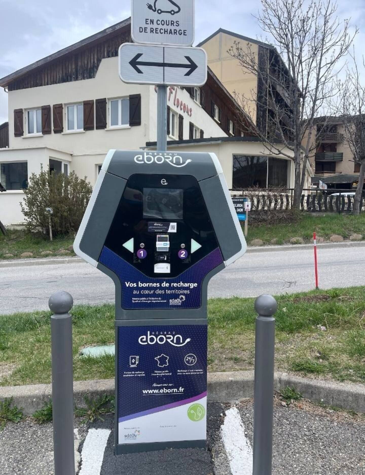 Una estación de carga para vehículos eléctricos con un cartel que indica que está en uso.