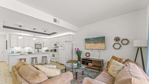 A modern living room with a beige sofa set, a glass coffee table, and a patterned rug. - Family Friendly Relax Villa (Kissimmee)