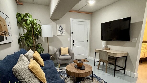 A modern living room with a blue sofa, a round coffee table, and a flat-screen TV.