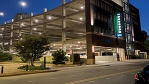 Un parking à plusieurs niveaux, avec un bâtiment moderne attenant.