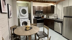 Cocina compacta con lavadora, microondas y electrodomésticos de acero inoxidable.