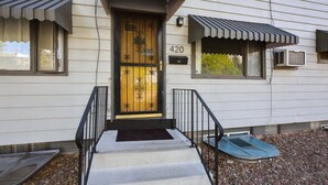 A two-story house with a front door, a mailbox, and a number '420' on the wall.