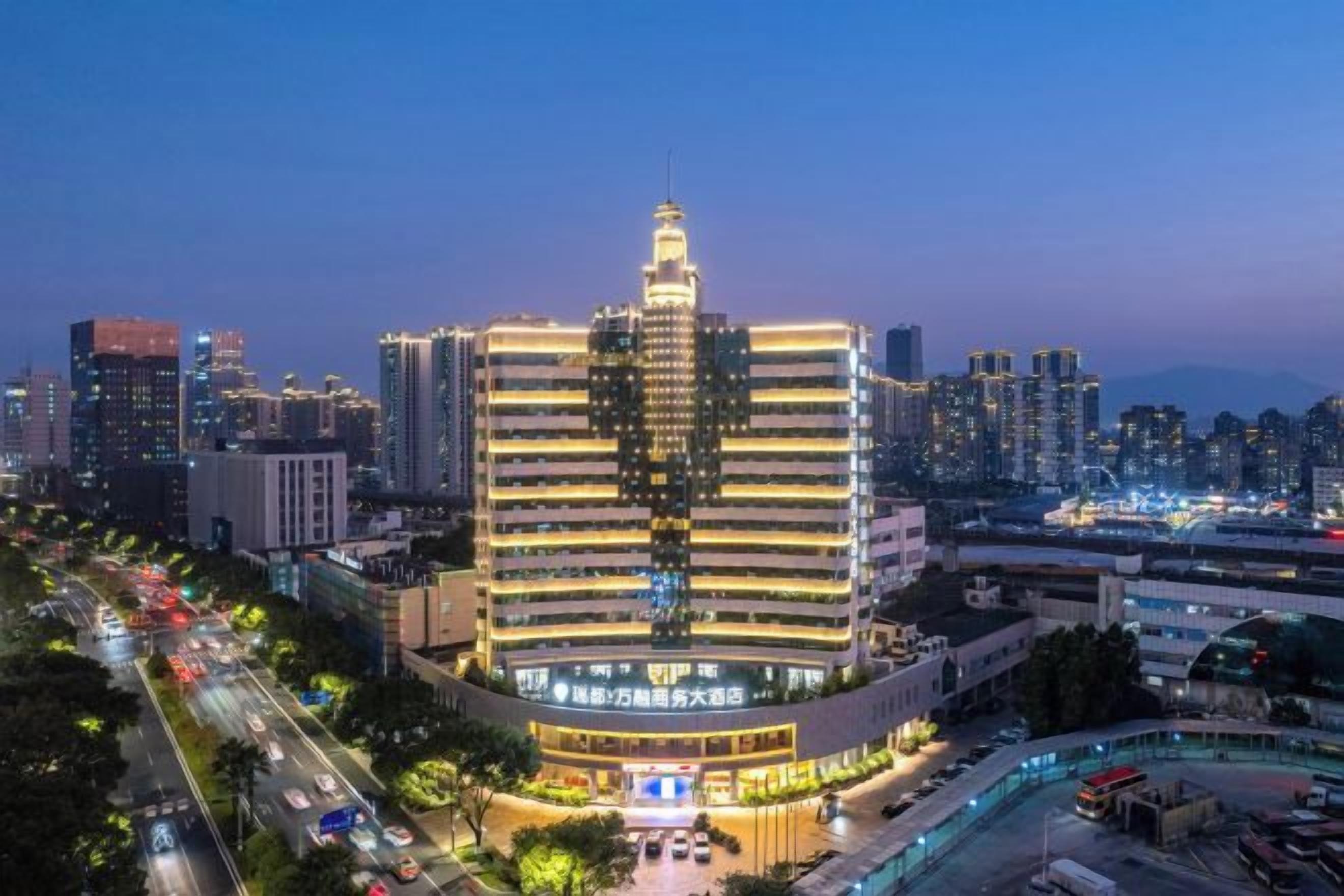 A multi-story hotel with a central atrium and a parking area in front.