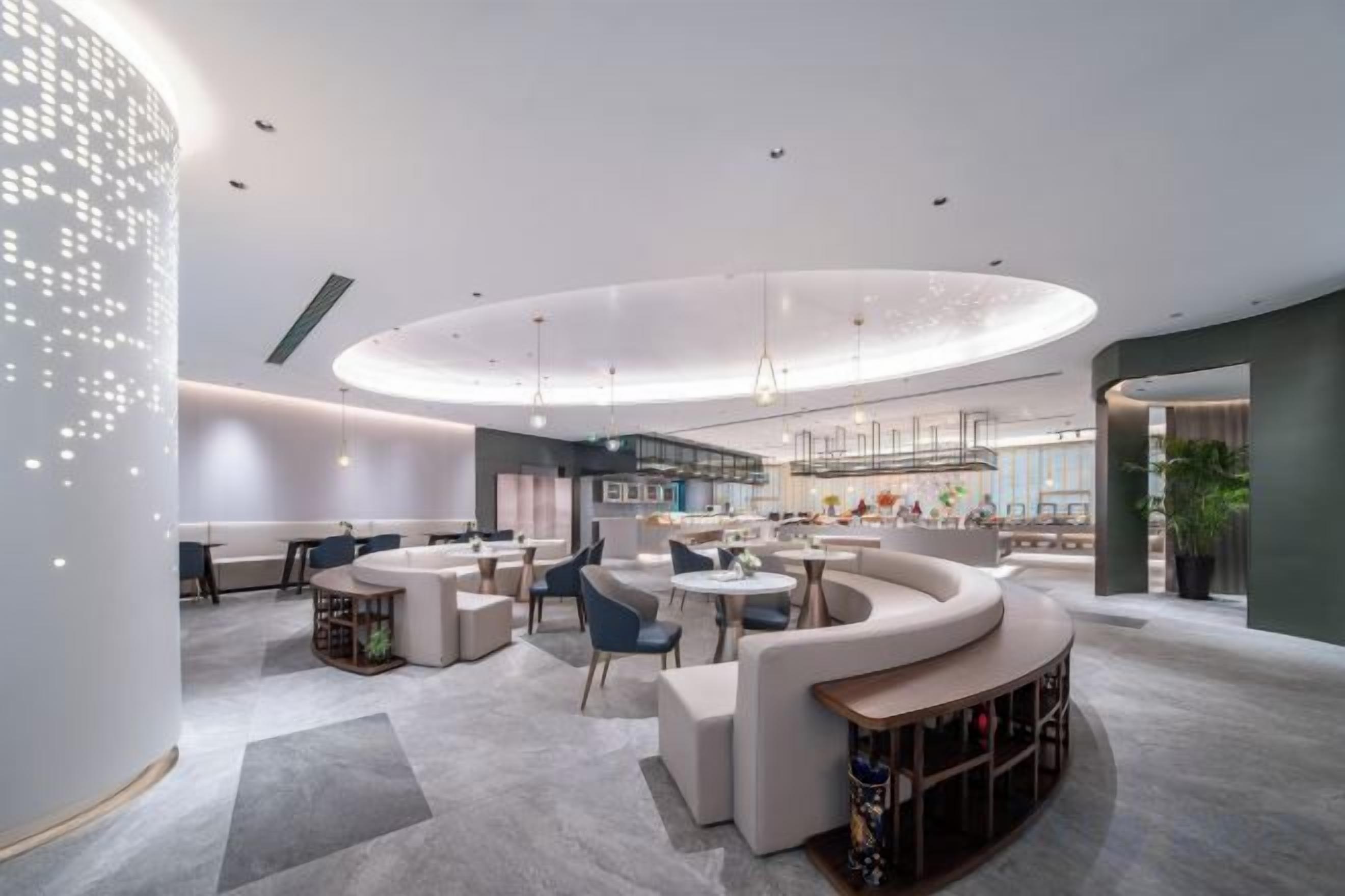 A modern interior with a circular seating area, a bar, and a reception desk.