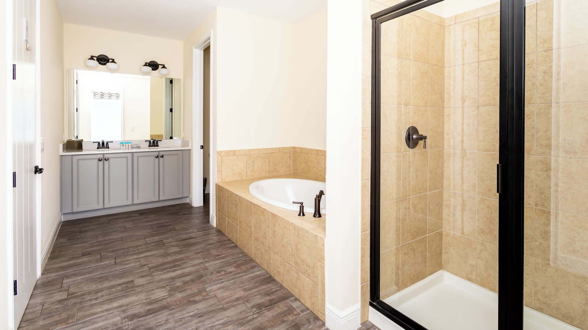 A bathroom with a walk-in shower, a freestanding bathtub, and a vanity with a mirror and sink.