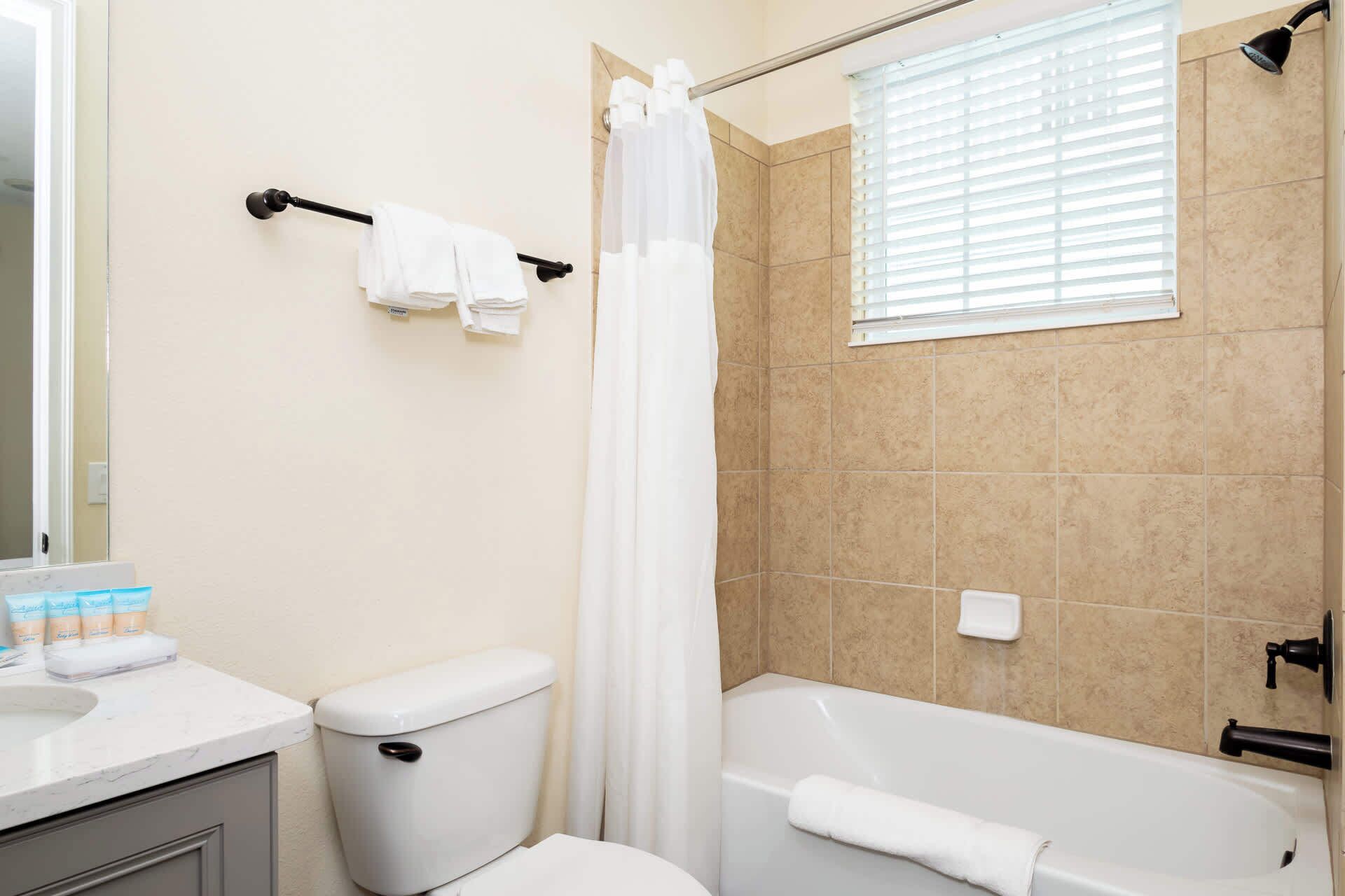 Ein Badezimmer mit Toilette, Badewanne und Duschvorhang.