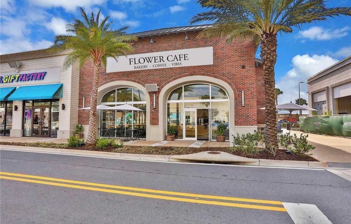 A building with a sign reading "Flower Cafe" and "Bakery - Coffee - Vibes".
