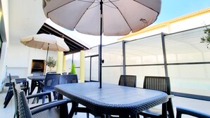 An outdoor seating area with tables and chairs, covered by umbrellas, and a view of the sky. - Milfontes Guest House (Odemira)