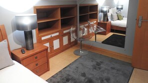 A bedroom with a bed, a nightstand, a lamp, a chair, a wardrobe, and a mirror. - Milfontes Guest House (Odemira)