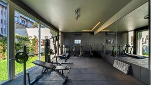 Et moderne fitnesscenter med forskellig træningsudstyr, store vinduer og et rent, minimalistisk design.