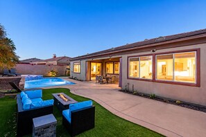 A residential property with a swimming pool, outdoor seating, and a covered patio area. - Indio 5BR Desert Oasis, Sleeps 14, Private Saltwater Pool and Spa (Indio)