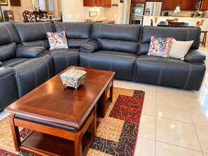 A sectional sofa with decorative pillows, a wooden coffee table, and a patterned rug in a modern living room. - Indio 5BR Desert Oasis, Sleeps 14, Private Saltwater Pool and Spa (Indio)